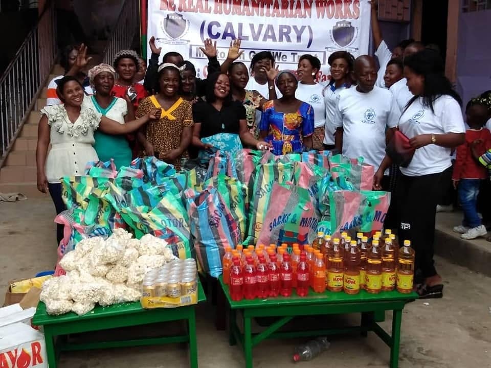 Be Real Humanitarian Works volunteers and community members gathered under the organization's banner in Calvary