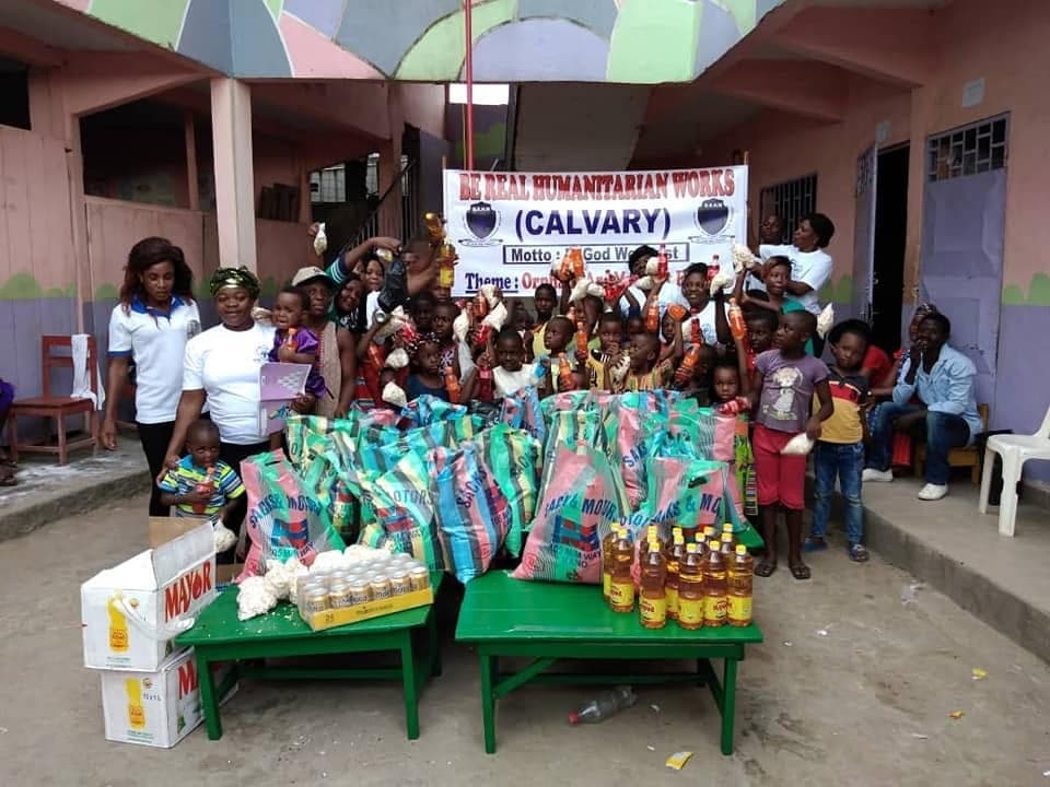 Be Real Humanitarian Works staff with schoolchildren at a community water point